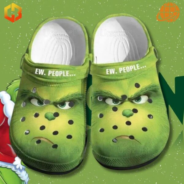 Ew People Grinch Crocs Shoes featuring detailed Grinch face and "EW. PEOPLE..." strap, set in a snowy Christmas scene.