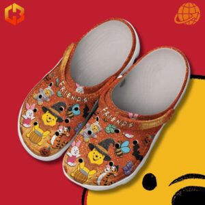 Close-up of FRIENDS Winnie-the-Pooh Crocs Shoes on red and yellow background, showing detailed character designs.