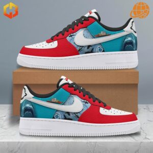 Jaws-themed Nike Air Force Shoes showcasing red, white, and teal color blocking with shark artwork, displayed on and beside a cardboard box.